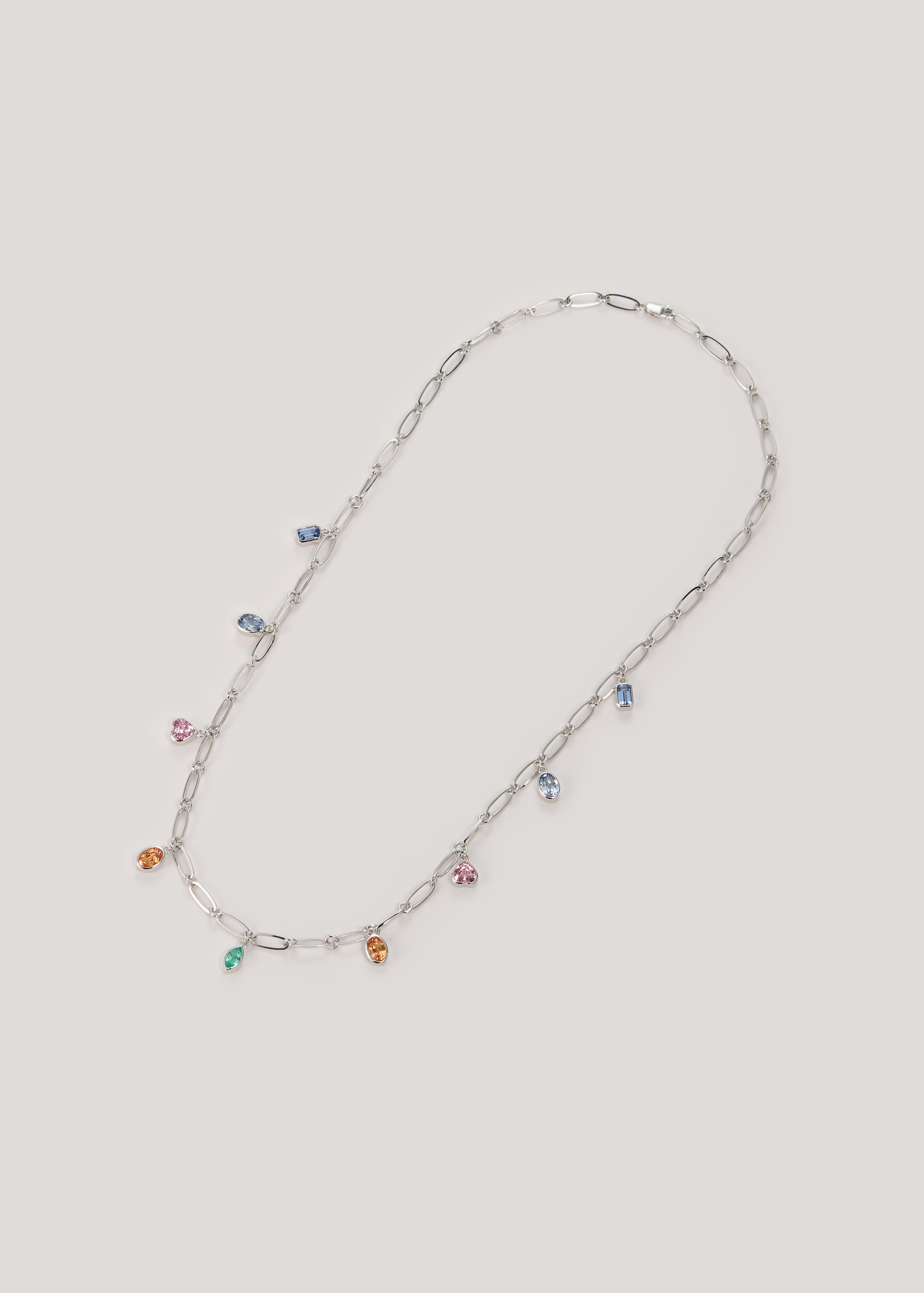 Platinum necklace featuring multi-colored gemstones, including blue sapphire, pink sapphire, Padparadscha sapphire, and Tsavorite. The necklace has a delicate link chain design, with gemstones evenly spaced along it, creating a cascading effect.